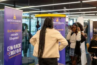 Étudiantes écoutant le podcast Convaincre et Émouvoir sur la borne d'écoute